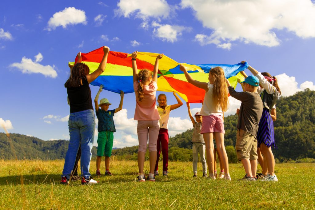 Children playing together holding a sheet over their heads as a game