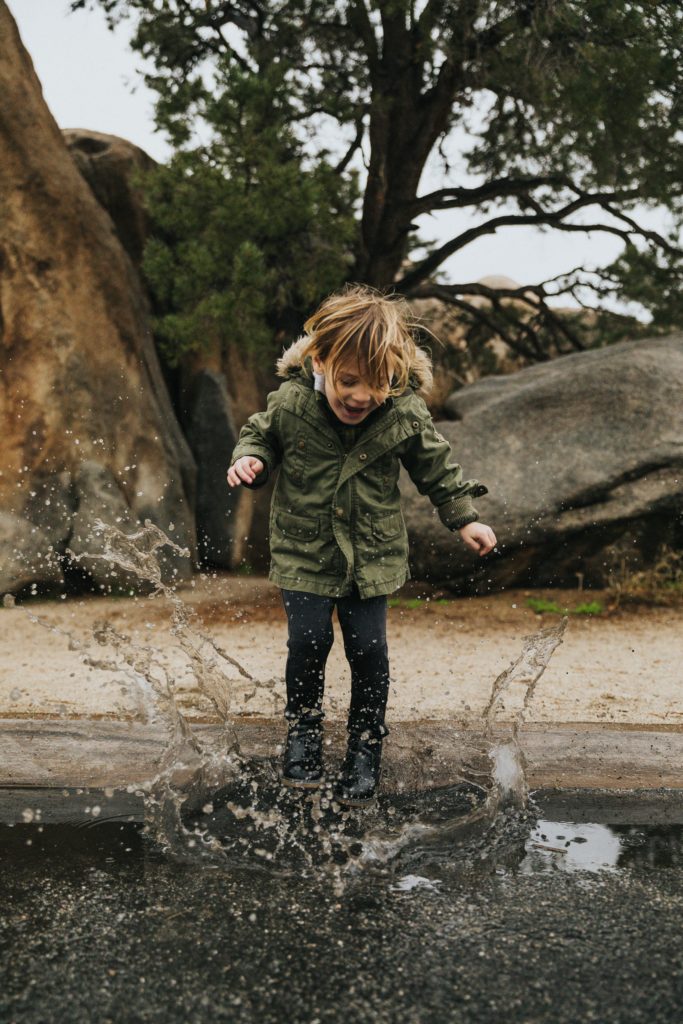 A child making a splash in a puddle of water