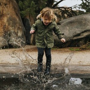 A child making a splash in a puddle of water