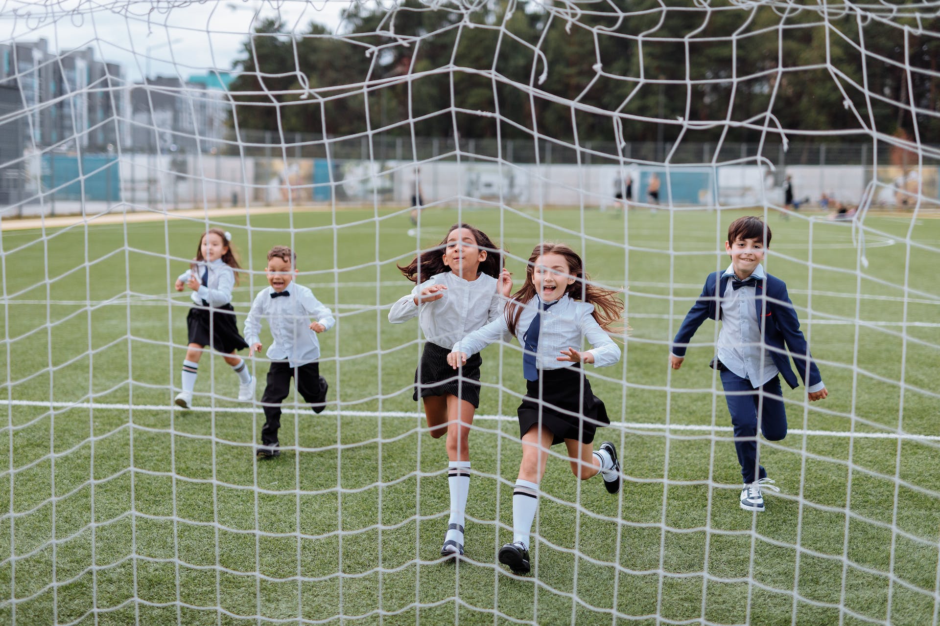 A group of school children running towards a soccer goal, long-term goals can help to motivate and encourage students