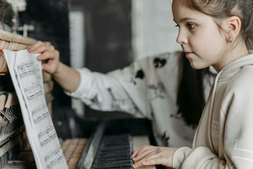 A child learning an instrument in this case a piano